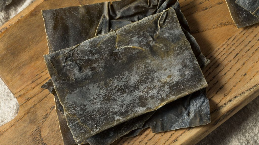 Trozo de alga kombu seca sobre tabla de madera